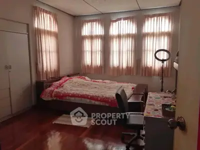 Cozy bedroom with natural light and wooden flooring