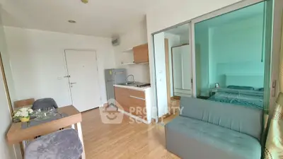 Modern open-plan living room with compact kitchen and cozy dining area in a stylish apartment.