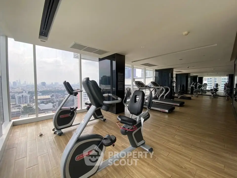 Spacious gym with city view in modern high-rise building