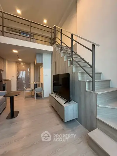 Modern loft apartment with stylish staircase and open living area, perfect for urban living.