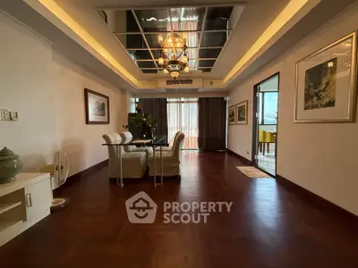 Spacious dining area with elegant lighting and wooden flooring in a modern apartment.