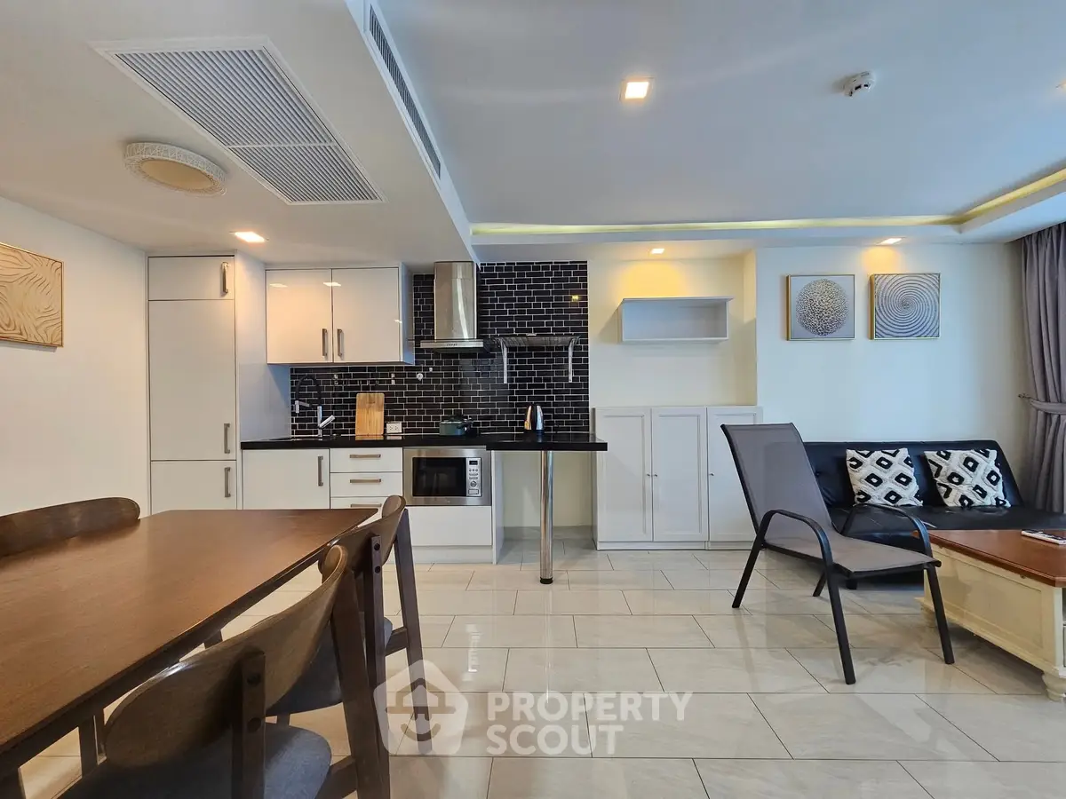 Modern open-plan living room and kitchen with sleek design and stylish furniture.