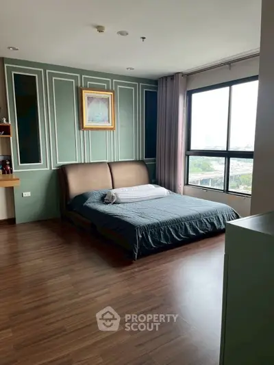 Spacious bedroom with elegant decor and large window offering city views