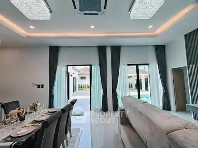 Luxurious modern living room with elegant dining area and pool view, perfect for entertaining.