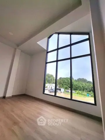 Spacious room with large floor-to-ceiling window offering scenic views and abundant natural light.