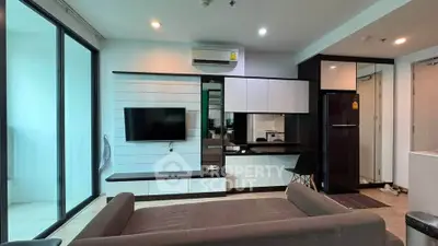 Modern living room with sleek furniture and built-in TV unit, featuring a cozy sofa and stylish decor.