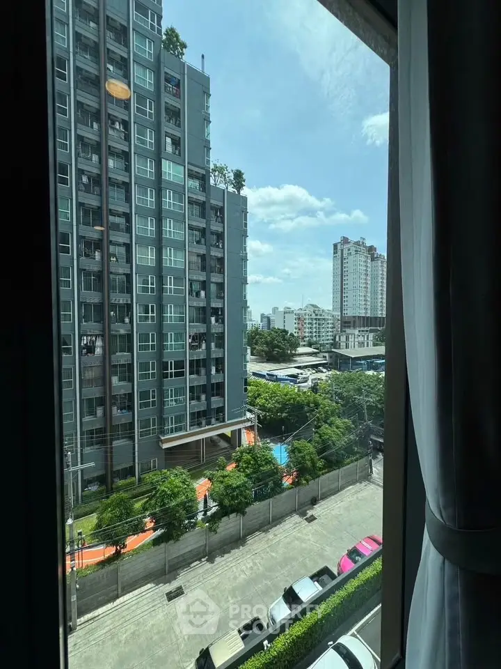 Stunning urban view from high-rise apartment window showcasing cityscape and modern architecture.
