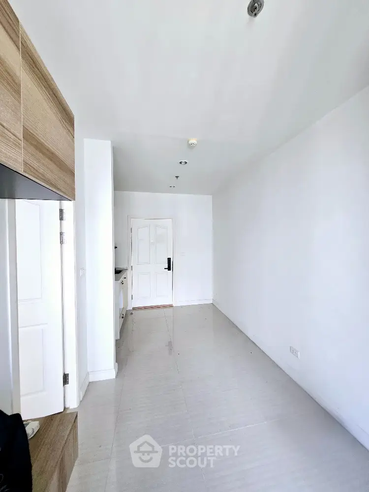 Minimalist white interior with wooden accents and tiled flooring, perfect for modern living.