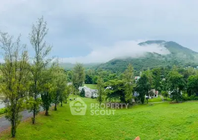 Scenic view of lush green landscape with houses and mountains, perfect for serene living.