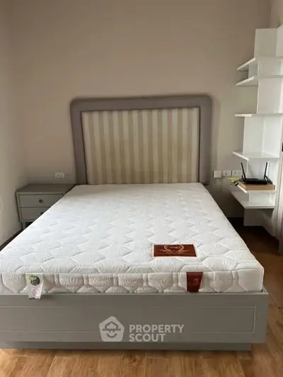 Spacious bedroom with modern bed and stylish shelving, perfect for a cozy and organized living space.