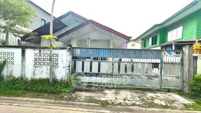 Charming suburban house with gated entrance and lush greenery