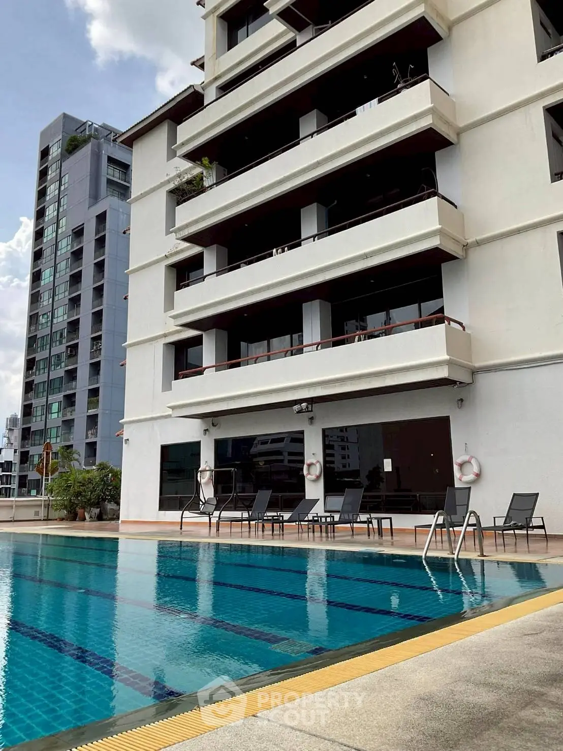 Luxurious apartment building with poolside view and modern amenities.