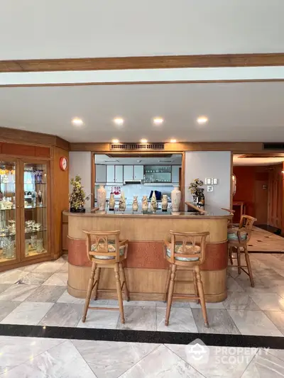 Elegant home bar with wooden stools and marble flooring in luxury residence