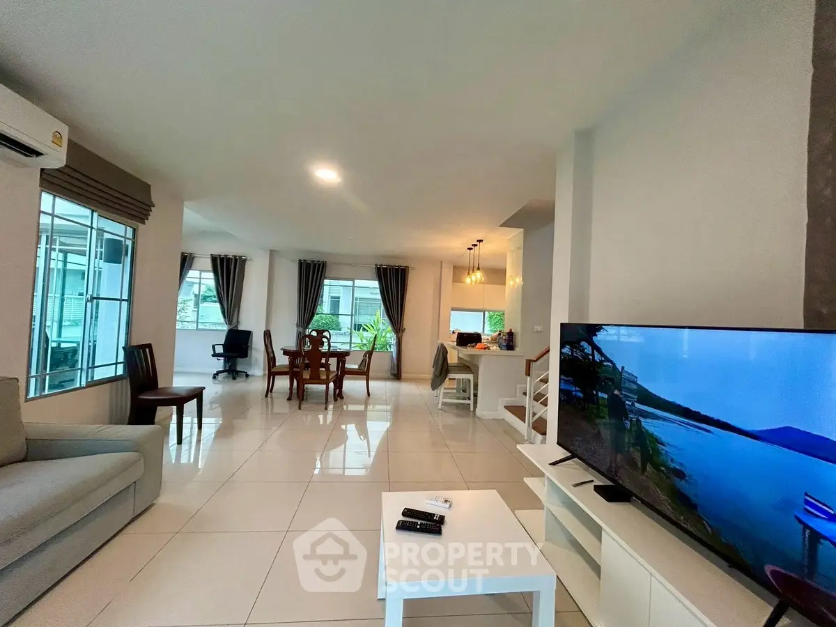 Spacious modern living room with open layout and large windows for natural light.