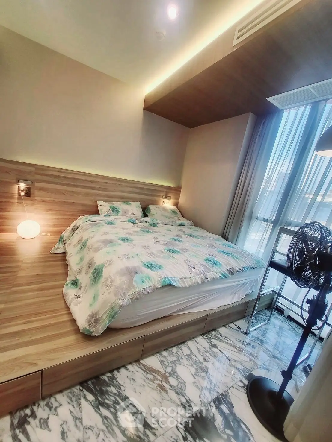 Modern bedroom with stylish decor and large windows offering natural light.