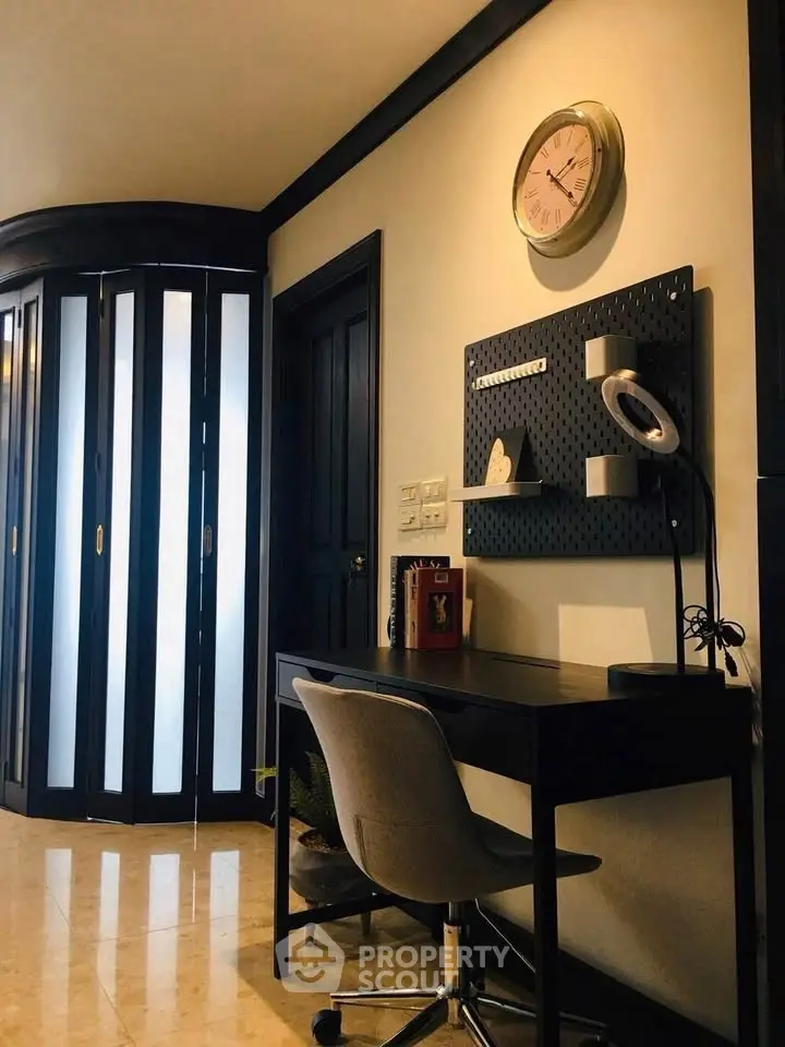 Modern study area with sleek desk and chair, wall clock, and stylish decor in a contemporary home.