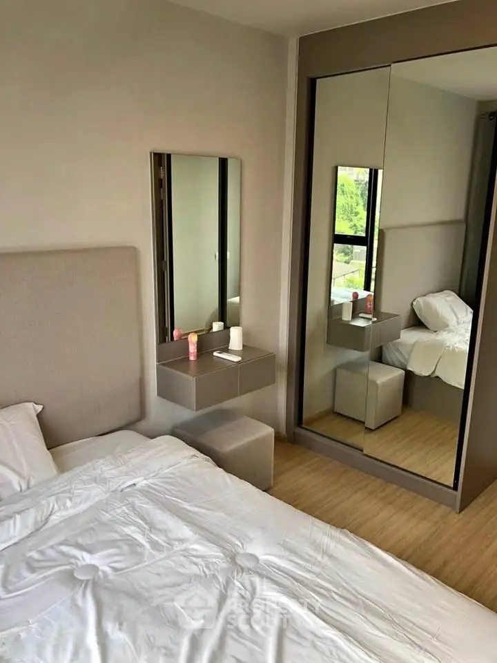 Modern bedroom with mirrored wardrobe and cozy bed in stylish apartment.