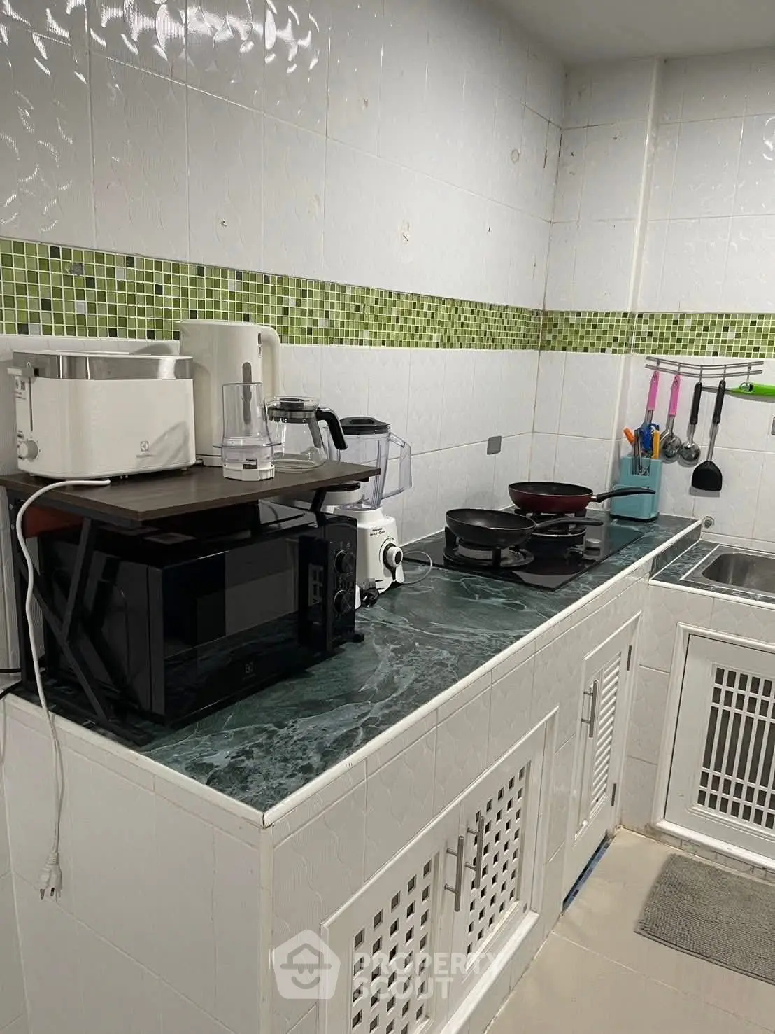 Modern kitchen with appliances and green tile backsplash