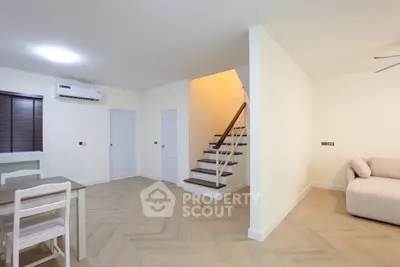 Spacious modern living room with elegant staircase and cozy seating area