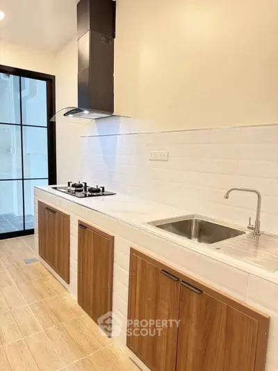 Modern kitchen with gas stove and sleek cabinetry in a stylish apartment.