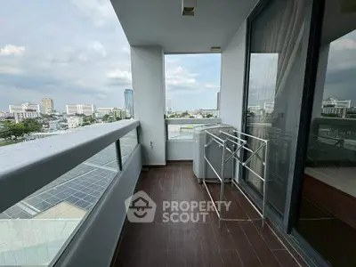 Spacious balcony with city view and laundry area in modern apartment