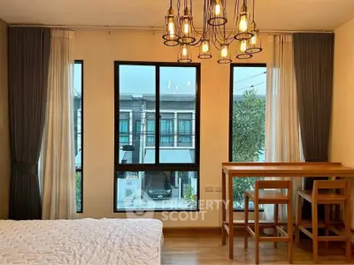 Modern bedroom with large windows and stylish lighting, offering a cozy and inviting atmosphere.