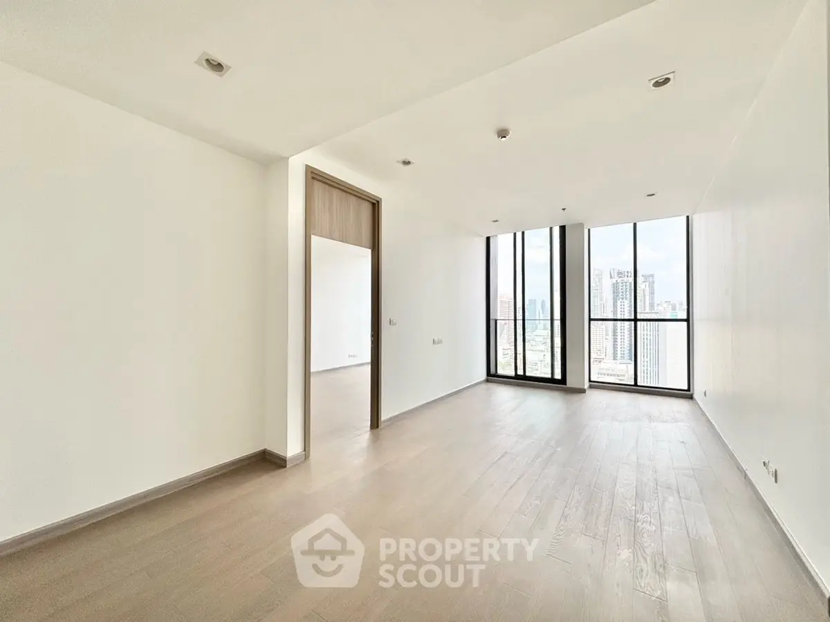 Spacious modern living room with floor-to-ceiling windows and city view