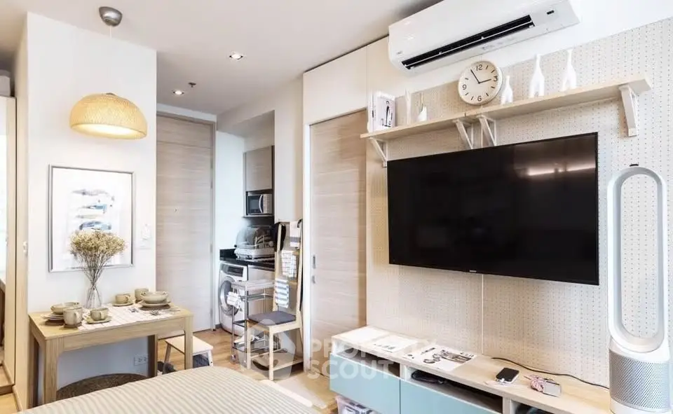 Modern studio apartment with stylish decor, featuring a wall-mounted TV and compact dining area.