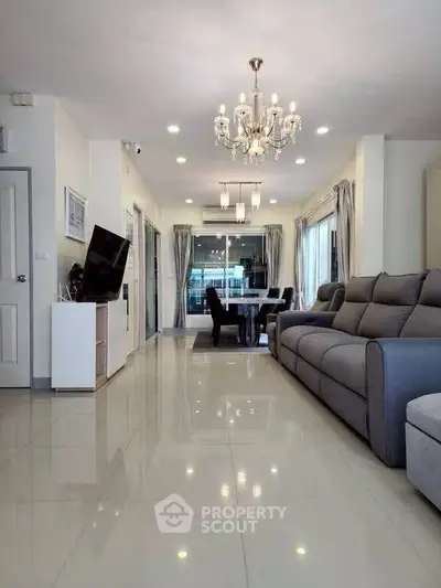Spacious modern living room with elegant chandelier and sleek furnishings