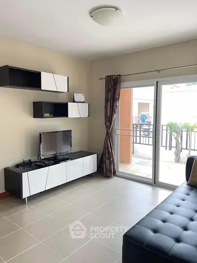 Modern living room with sleek furniture and large sliding glass doors to balcony