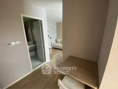 Cozy apartment interior with study area and partial bathroom view, ideal for modern living.