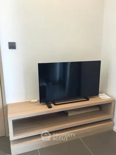 Modern living room with sleek TV setup on stylish wooden stand, perfect for entertainment.