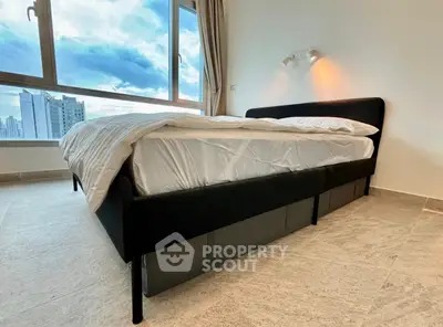 Modern bedroom with large window and city view, featuring a stylish bed and elegant flooring.