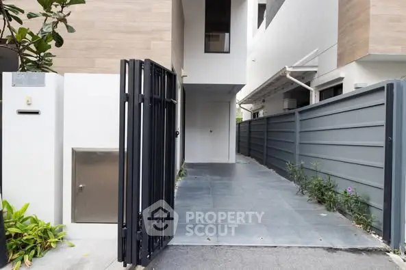 Modern townhouse entrance with sleek gate and tiled pathway