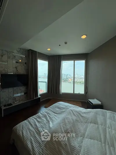 Luxurious bedroom with stunning river view and modern decor in high-rise apartment.