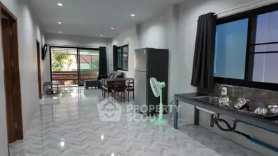 Spacious open-plan living area with modern kitchen and large windows