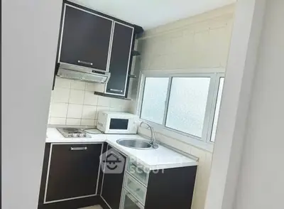 Modern compact kitchen with sleek cabinetry and built-in appliances