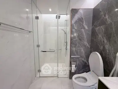 Luxurious modern bathroom with glass shower and marble accents