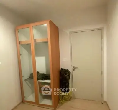 Compact storage area with wooden wardrobe and closed door in modern apartment.