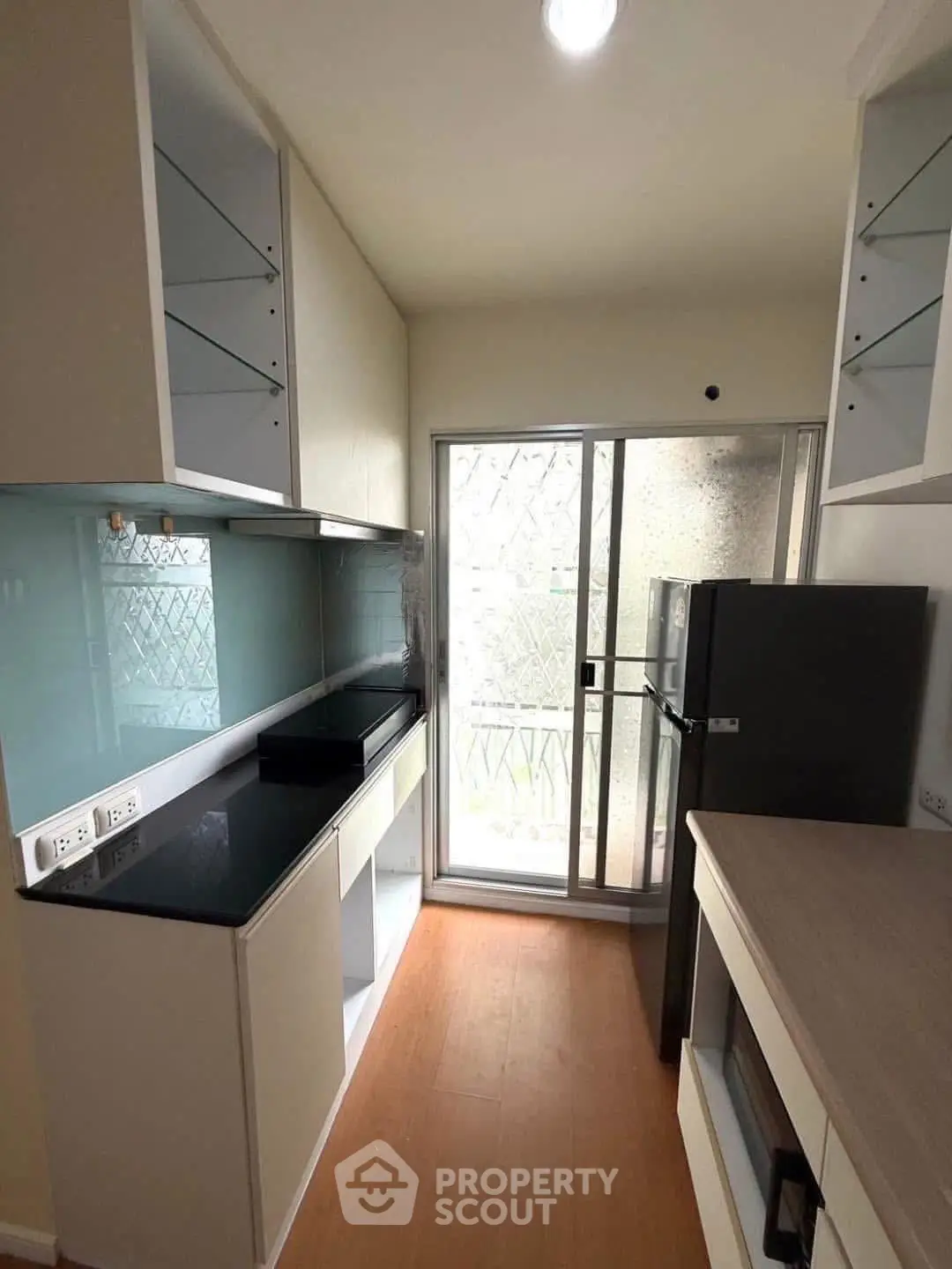 Modern kitchen with sleek cabinetry and large window for natural light.