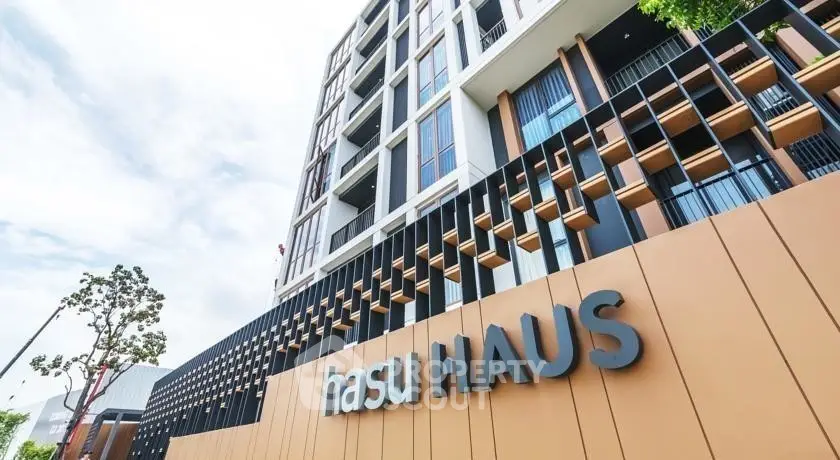 Modern apartment building exterior with stylish facade and lush greenery.