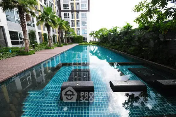 Luxurious condominium pool area with lush greenery and modern design.