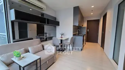 Modern living room with sleek furniture and open kitchen layout in a stylish apartment.