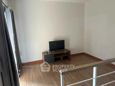 Spacious living room with wooden flooring and modern TV setup