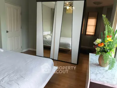 Spacious bedroom with mirrored wardrobe and elegant decor