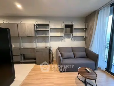 Modern living room with sleek shelving and cozy sofa, featuring a stylish round coffee table.