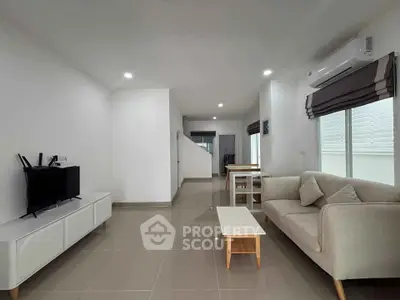 Modern living room with sleek furniture and neutral tones, featuring a cozy sofa and flat-screen TV.