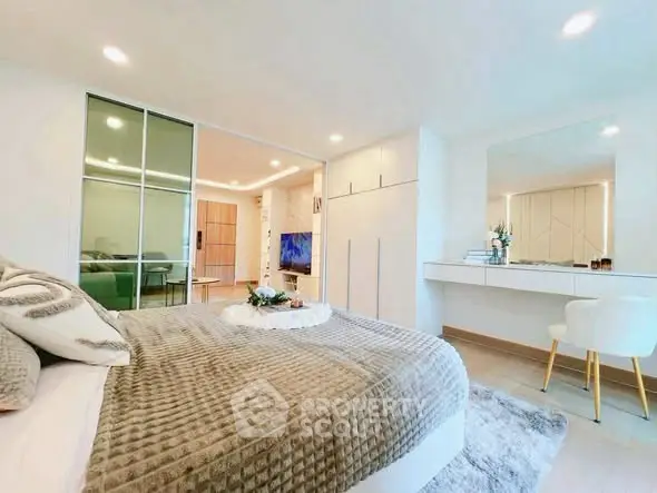 Modern bedroom with stylish decor and sliding glass doors leading to a spacious living area.