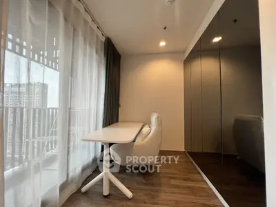 Modern study area with sleek desk and chair, floor-to-ceiling windows, and city view.