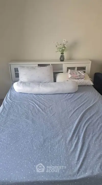 Cozy bedroom with a neatly made bed and elegant headboard, perfect for relaxation.